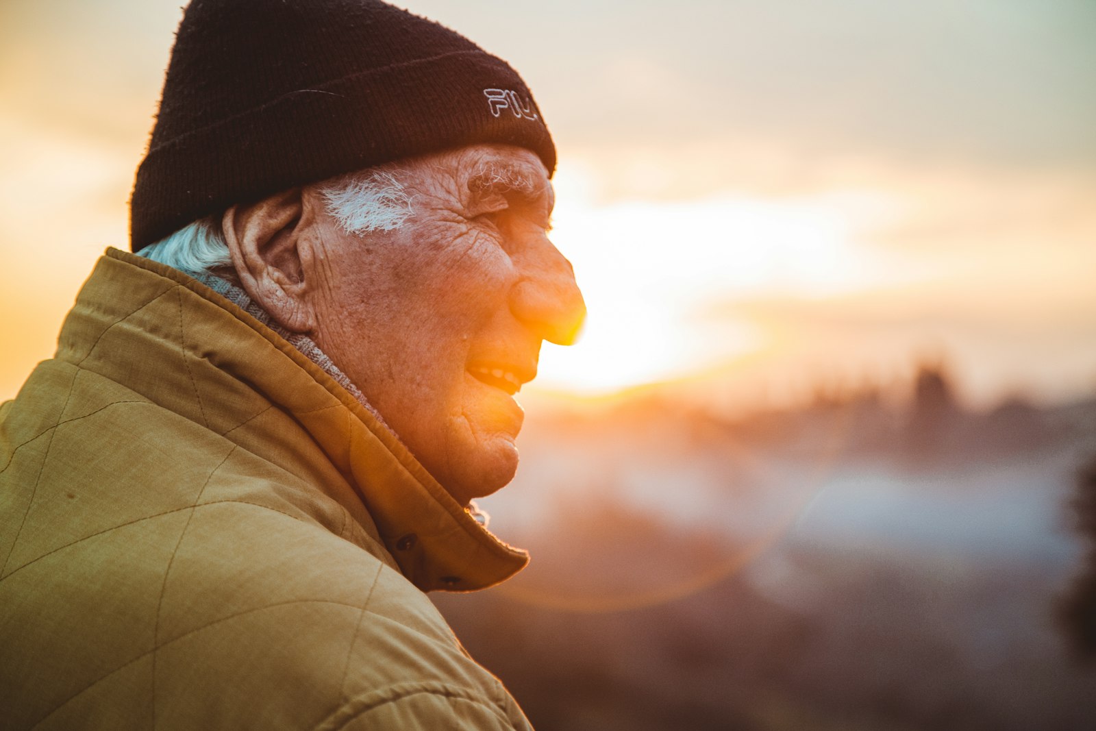 Older man in a knit cap looking out, contemplative